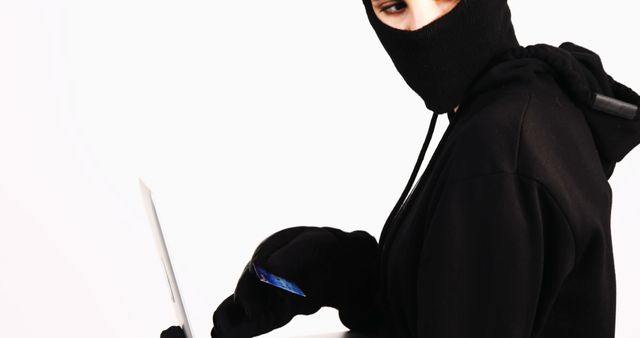 Mysterious Person in Black Hoodie Using a Laptop with Mask - Download Free Stock Images Pikwizard.com