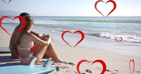 Romantic Couple on Beach Overlaid with Red Hearts