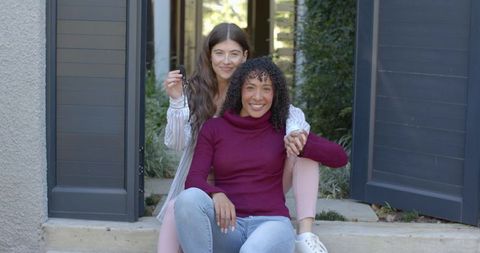 Diverse Female Couple Relaxing Together on Porch Steps