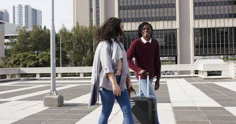 Diverse Friends Walking with Luggage on Urban Rooftop Plaza, Casual Travel Moment
