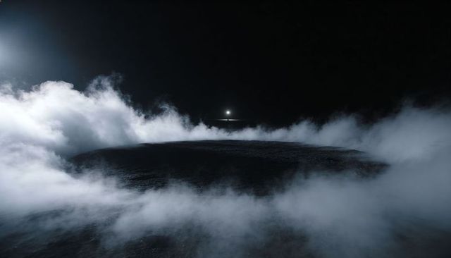 Dark rocky plateau rising through low fog under distant haloed light