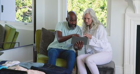 Mature couple planning wedding with tablet at home