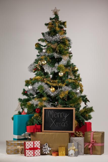 Merry x-mas message on slate with presents and christmas tree during christmas time