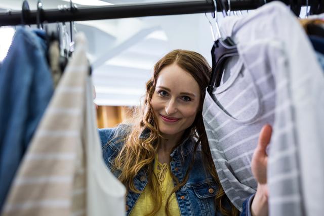 Woman choosing clothes from clothes rack in mall