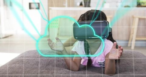 Child Reaching into Holographic Cloud While Wearing VR Headset on Gray Cushion