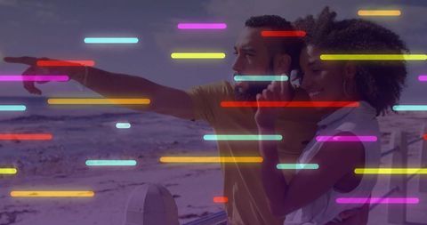 Couple Pointing at Ocean, Enjoying Scenic Beach View