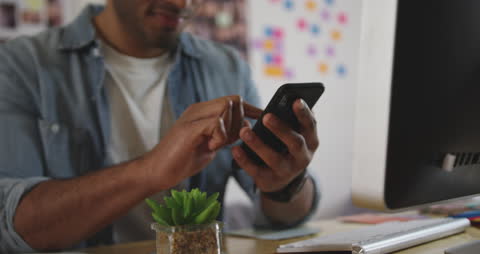 Man Texting on Smartphone in Creative Office Environment