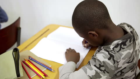 Pupil Drawing with Colored Pencils in Classroom Environment