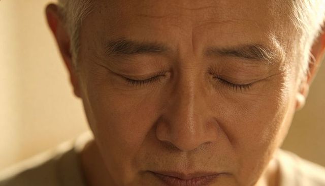 Senior asian man resting with eyes closed closeup portrait serene contemplative calm