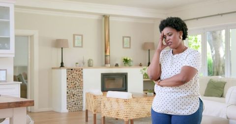 Woman appearing disappointed or concerned at home