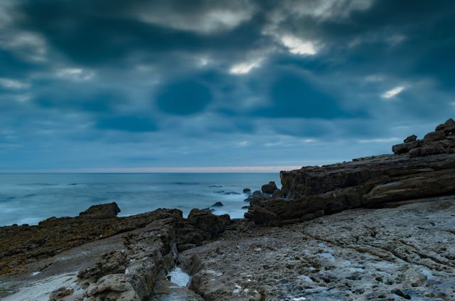 Dramatic Seaside Cliff under Dark Cloudy Sky at Dusk - Download Free Stock Images Pikwizard.com