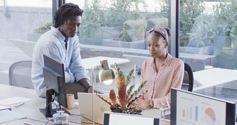 Team collaborating on laptop in modern office
