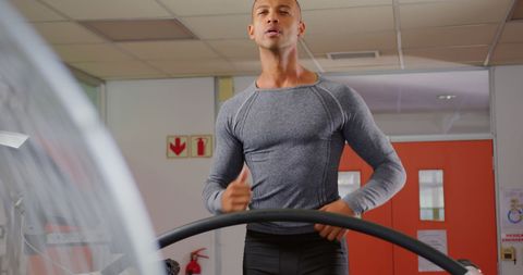 Man jogging on treadmill at modern fitness center
