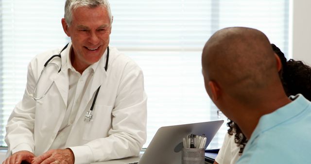 Smiling Doctor Consulting Patients in Modern Medical Office - Download Free Stock Images Pikwizard.com