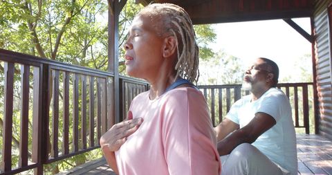 Senior Couple Practicing Yoga and Meditation on Sunlit Porch