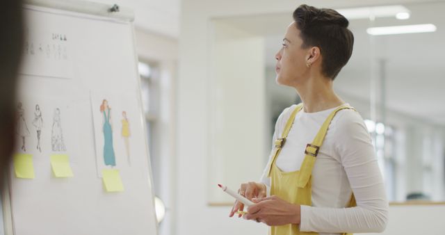 Fashion Designer Reviewing Garment Sketches on Whiteboard in Studio - Download Free Stock Images Pikwizard.com