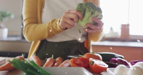 Woman Cooking with Fresh Vegetables in Sunlit Kitchen