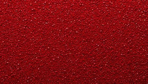 Macro glossy red bead texture shimmering with specular highlights for abstract backgrounds