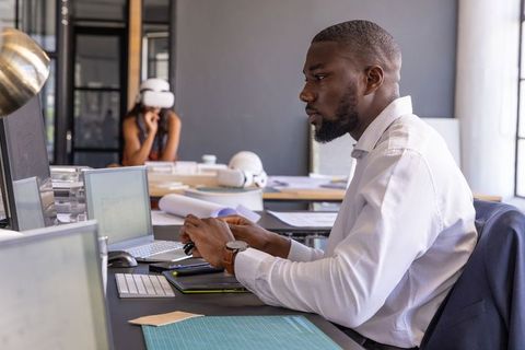 Focused colleague working at modern office workspace with technology
