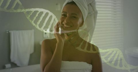 Smiling woman in towel touching cheek with dna overlay for skincare wellness and biotech