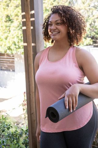African american woman enjoying yoga outdoors on sunny patio