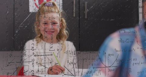 Elementary student writing math at desk with transparent equations overlay and smiling
