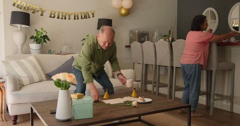 Mature Couple Setting Up for Birthday Celebration at Home