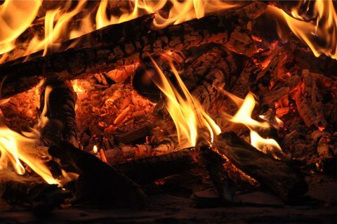 Glowing Campfire Flames and Smoldering Wood Embers Creating Warmth and Rustic Ambience