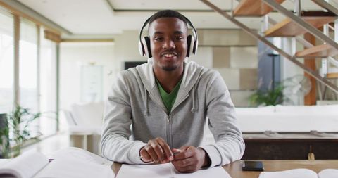 Young Man Studying at Home Wearing Headphones