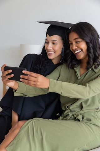 Graduate Taking Selfie with Friend Celebrating Achievement with Joyful Smiles