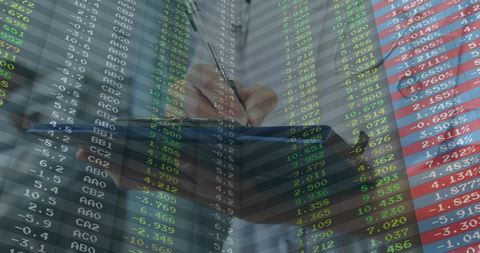 Executive writing notes with financial market data overlay, stock tickers and analytics dashboard