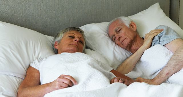 Senior couple sleeping in the bedroom at home