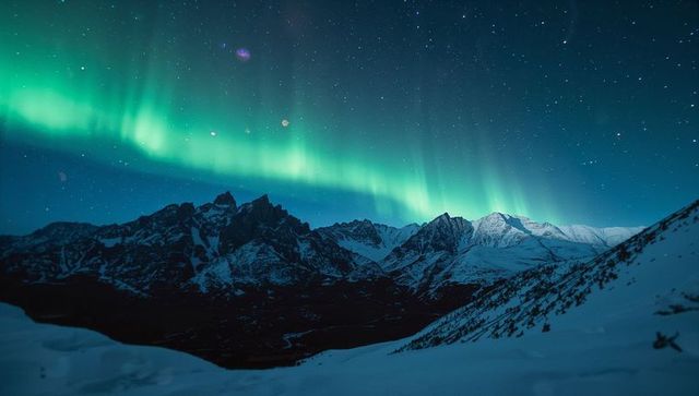 Serene Northern Lights Over Snowy Mountains at Night