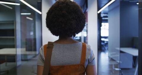 Businesswoman Walking in Modern Office with Coffee Cup