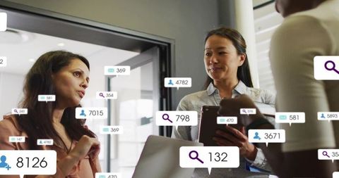 Business team analyzing social metrics and analytics overlays with devices in boardroom