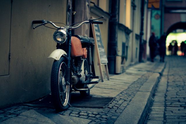 Vintage Motorcycle Parked on Cobblestone Street at Dusk - Download Free Stock Photos Pikwizard.com