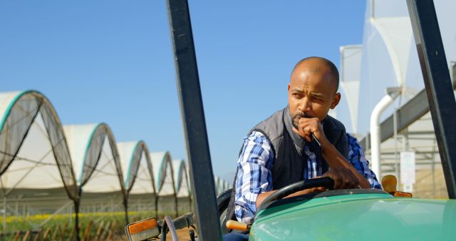 Thoughtful African American Farmer Operating Tractor on Farm - Download Free Stock Images Pikwizard.com