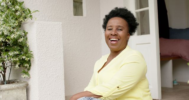 Smiling Woman Sitting Outdoors by House Entrance - Download Free Stock Images Pikwizard.com