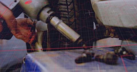Mechanic tightening wheel lug with impact wrench close-up, red tech grid overlay