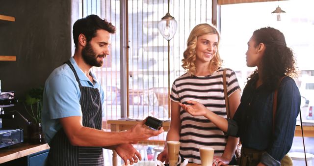 Barista Providing Contactless Payment While Friends Chat - Download Free Stock Images Pikwizard.com