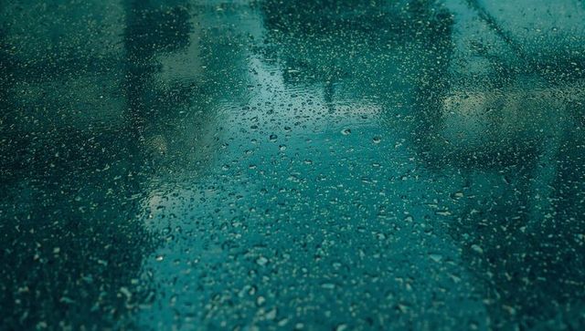 Teal Tinted Glass Panel with Shimmering Water Droplets