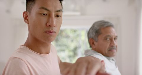 Physiotherapist Assisting Senior Man with Arm Stretching