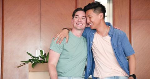 Smiling Diverse Male Couple Celebrating Togetherness Indoors