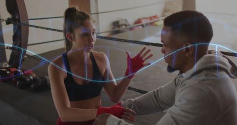 Female boxer and coach discussing strategy in ring with dna helix overlay