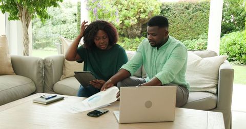 African American Couple Analyzing Finances with Technology at Home