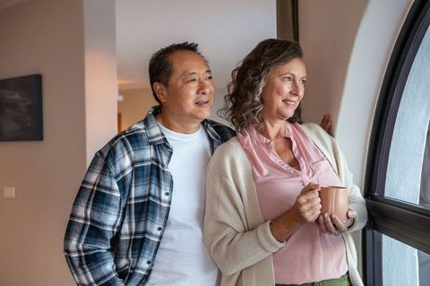 Senior Couple Reflecting at Home by Arched Window