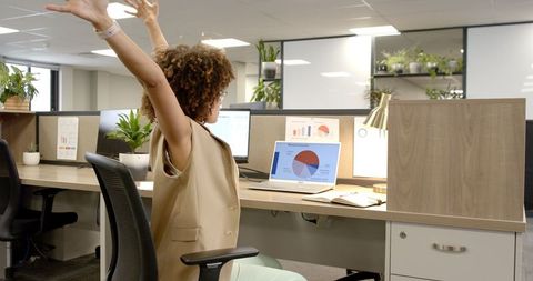 Successful Businesswoman Celebrating Achievement at Modern Workspace