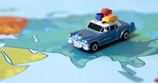 A miniature car with luggage on top is placed on a colorful map, symbolizing travel and adventure. It evokes the excitement of road trips and exploring new destinations.
