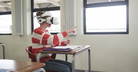 Young Schoolgirl Learning with Virtual Reality in Classroom