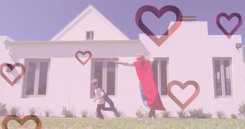 Mother and Child Playing Superheroes Outside Modern Home